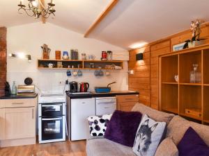a living room with a couch and a kitchen at Oakwell Lodge in Rainham