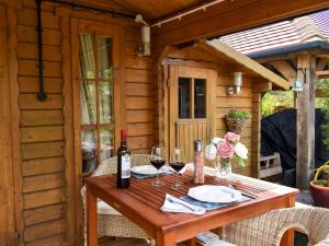 a wooden table with glasses of wine on a patio at Oakwell Lodge in Rainham