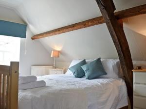 een slaapkamer met een wit bed met blauwe kussens bij 4 The Green in Richmond