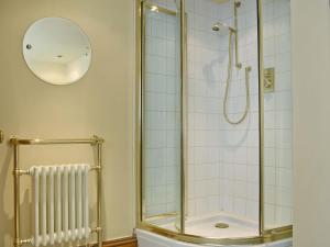 een badkamer met een douche en een glazen deur bij 4 The Green in Richmond
