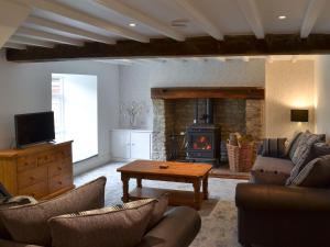 a living room with a couch and a fireplace at Whisperdale Barn in Broxa