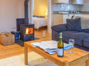 a living room with a wine bottle and glasses on a table at Camelia Cottage-uk37205 in Sancreed