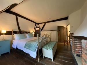 a bedroom with a bed and a bench in a room at Dairy Farm in Sherfield English