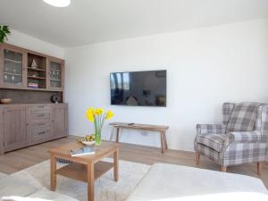 a living room with a tv and a chair and a table at Dolphin Heights in Torquay