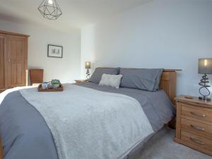 a bedroom with a large bed and a wooden dresser at Dolphin Heights in Torquay