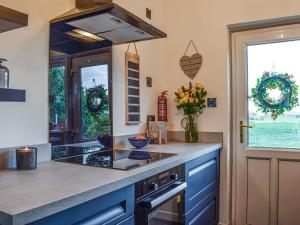 a kitchen with blue cabinets and a counter top at Dothan Farm Cottage in Cardenden