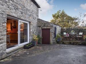 a stone house with a door and a patio at Barn House in Settle
