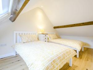 2 Betten in einem Zimmer mit weißen Wänden und Holzböden in der Unterkunft Horseshoe - Uk30759 in Bream