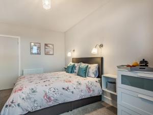 a bedroom with a large bed with blue pillows at Boyd Apartment in Largs