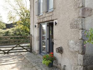 a door to a building with flowers on it at Threagill Cottage - Uk12913 in Warton