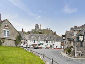 a street in a village with a castle in the background at Torvean in Wareham