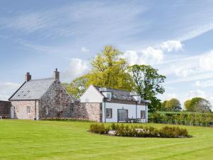 una vieja casa de ladrillo en un césped verde en Grieves Cottage - Uk11107 en Montrose