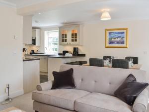 a living room with a couch and a kitchen at Grieves Cottage - Uk11107 in Montrose