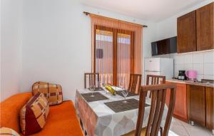 kuchnia ze stołem z 2 krzesłami oraz kuchnia z tableablish w obiekcie Cozy Apartment In Jurandvor w mieście Jurandvor