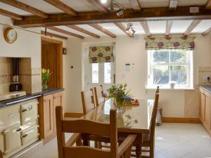 a kitchen with a table and chairs in a room at Span Carr Cottage in Ashover