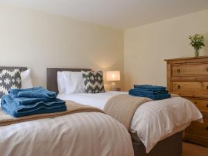 two beds sitting next to each other in a bedroom at Span Carr Cottage in Ashover
