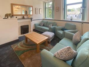 Brigham的住宿－The Oak Apartment，客厅设有蓝色的沙发和壁炉