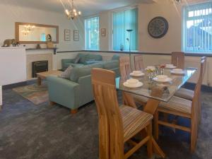 a living room with a table and a couch at The Oak Apartment in Brigham