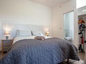 a bedroom with a large bed with a blue comforter at Meadows Edge - Uk30951 in Perranzabuloe