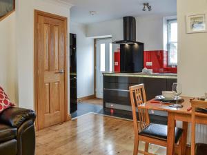 a kitchen with a table and a dining room at Carse View Cottage in Abernethy
