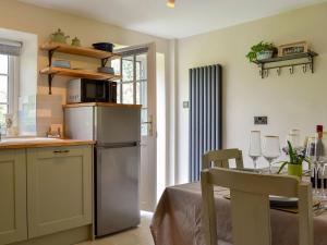 cocina con nevera de acero inoxidable y mesa en Keldholme Cottages 2 - Uk11488 en Kirkbymoorside