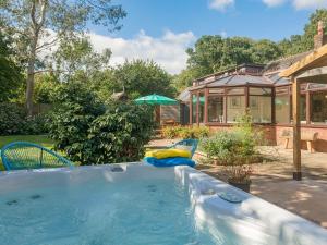 a swimming pool in a yard with chairs and a house at Wagtails in Milverton