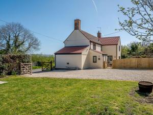 una casa blanca con una valla y un patio en Rathlin Cottage en Cambridge