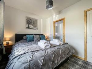 a bedroom with a bed with towels on it at Post Office Cottage in Skaill