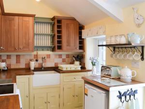 a kitchen with wooden cabinets and a white refrigerator at Lake View Cottage in Falstone