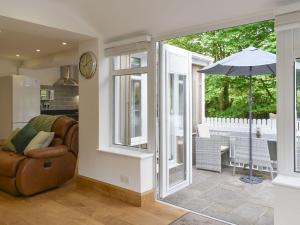 a living room with a chair and an umbrella at Tan Yr Ardd Bach in Llanwnda