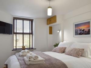 um quarto com uma cama com toalhas em Tan Yr Ardd Bach em Llanwnda