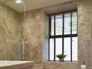 uma casa de banho com uma banheira e uma janela em Tan Yr Ardd Bach em Llanwnda