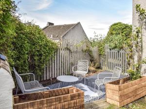 a patio with chairs and a table and a fence at Maisie Cottage in Saint Monance