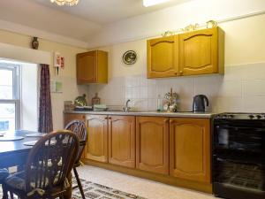 a kitchen with wooden cabinets and a table and a dining room at Hameldown-uk12423 in Widecombe in the Moor