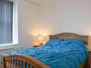 1 cama con edredón azul en un dormitorio en Duncan Square, en Whitehaven