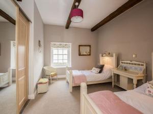 a childs bedroom with two beds and a window at The Coach House in Marrick