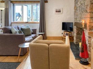 sala de estar con sofá y TV en The Old Fire Station en Ivybridge