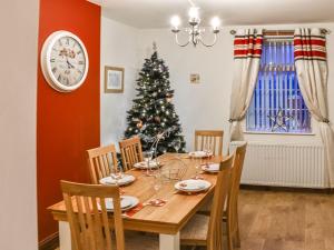 een eetkamer met een tafel en een kerstboom bij Stonebank Cottage - Uk35686 in Hunwick