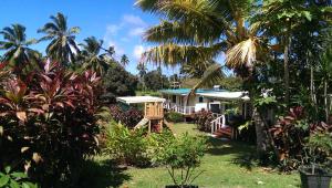 ein Haus inmitten eines Gartens mit Palmen in der Unterkunft JO's Farmstay-charming holiday farm close to famous Muri Beach in Rarotonga