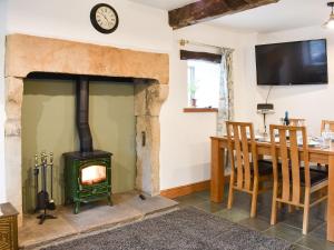 a fireplace in a dining room with a table and a stove at Ower Yonder in Ingleton