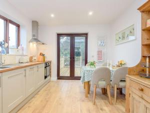 a kitchen with a table and chairs and a dining room at River Test View in Chilbolton