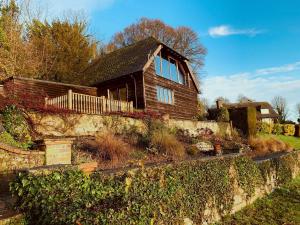 a house with a stone wall in front of it at River Test View in Chilbolton