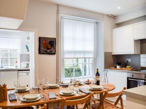 a kitchen with a wooden table with wine glasses at Isabel's House in St. Andrews