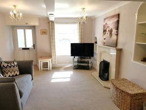 a living room with a couch and a television at Hillside Farm Cottage in Grange Over Sands