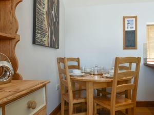 a kitchen with a wooden table and chairs at The Barn in Baltonsborough