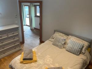 a bedroom with a bed and a dresser with a mirror at The Barn in Baltonsborough