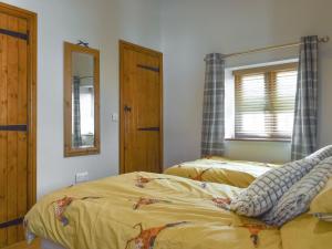 a bedroom with two beds and a mirror at The Barn in Baltonsborough