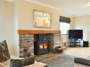 a living room with a fireplace and a mirror at Chapel House in Dearham