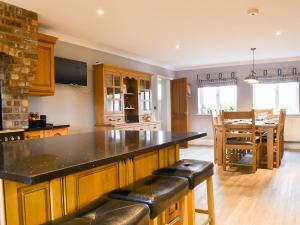 a kitchen with a large island with black counter top at Chapel House in Dearham