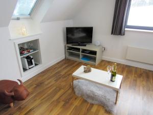 a living room with a tv and a table at Drovers Apartment in Tomatin